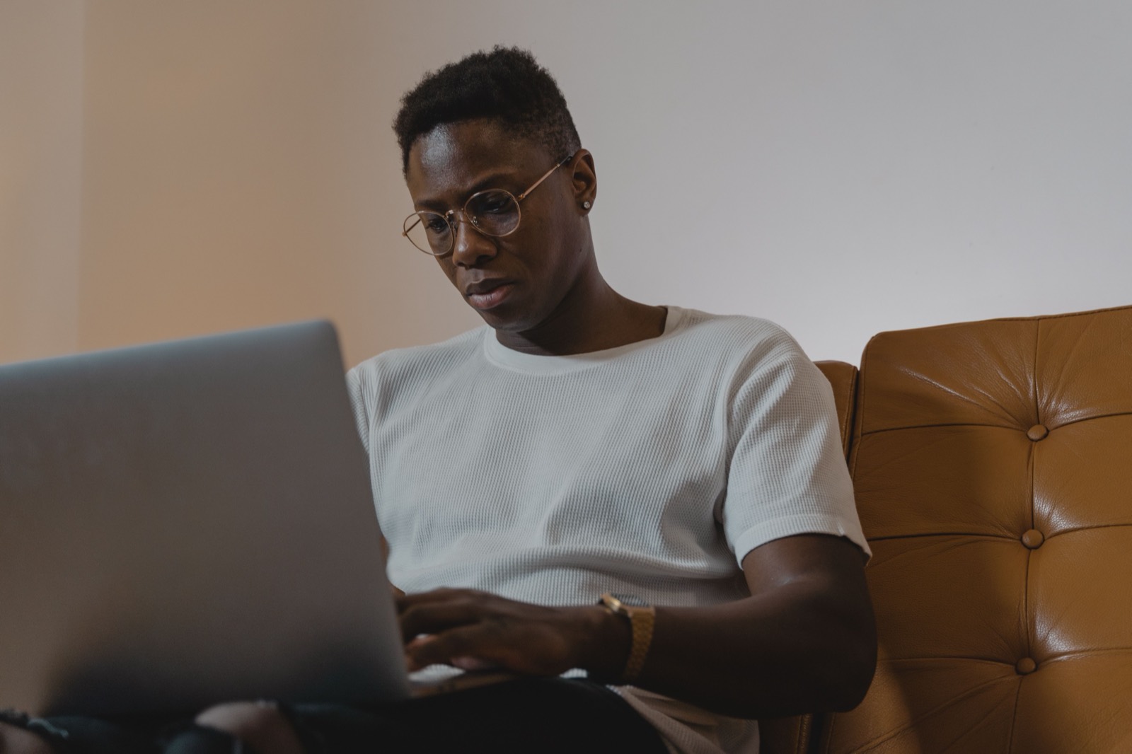 A person in glasses working on a laptop, editing a document.
